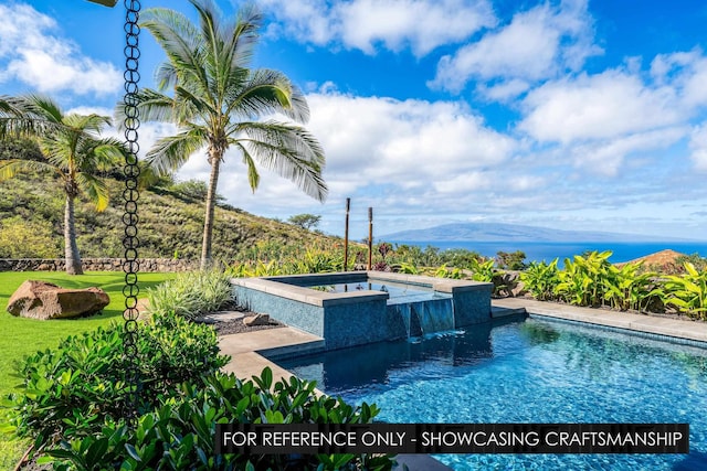 view of pool with a mountain view, a lawn, and a pool with connected hot tub