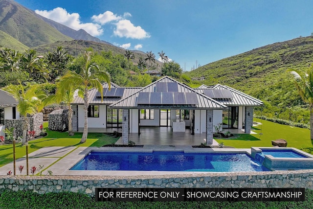 back of house with an in-ground hot tub, a lawn, roof mounted solar panels, an outdoor pool, and a patio