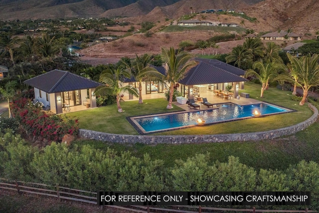 swimming pool with a lawn, a patio area, and a mountain view