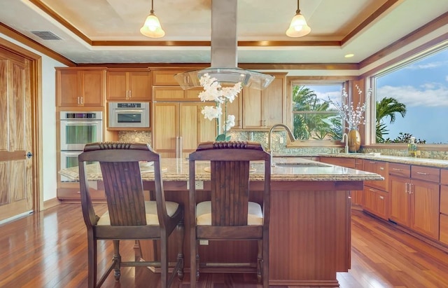 kitchen featuring light stone countertops, sink, pendant lighting, and double oven