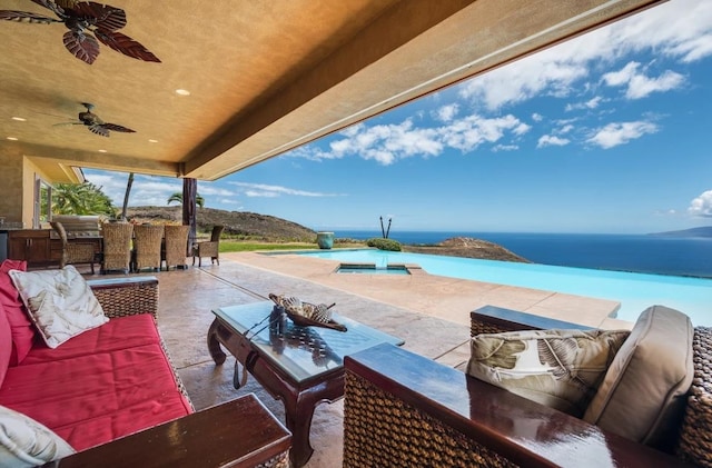 view of patio / terrace featuring ceiling fan, an outdoor hangout area, and a water view