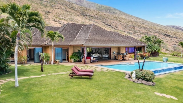 view of pool with a lawn, an outdoor hangout area, a mountain view, and a patio