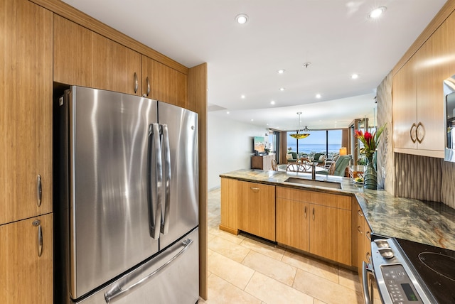 kitchen featuring stone countertops, light tile patterned flooring, kitchen peninsula, and stainless steel appliances