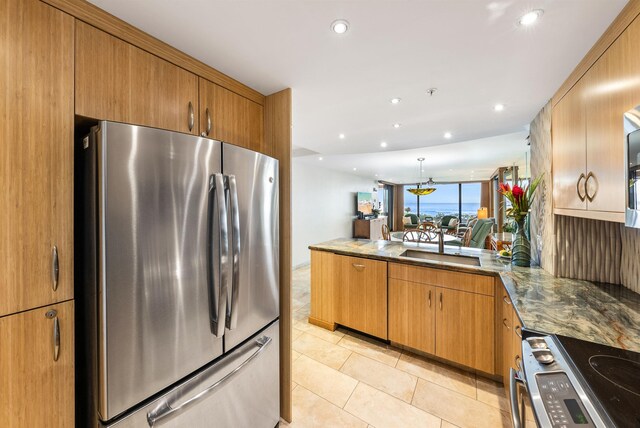 110 Kaanapali Shores Pl Unit 109, Lahaina, HI 96761 - kitchen featuring stainless steel appliances, a peninsula, light tile patterned floors, brown cabinetry, and recessed lighting