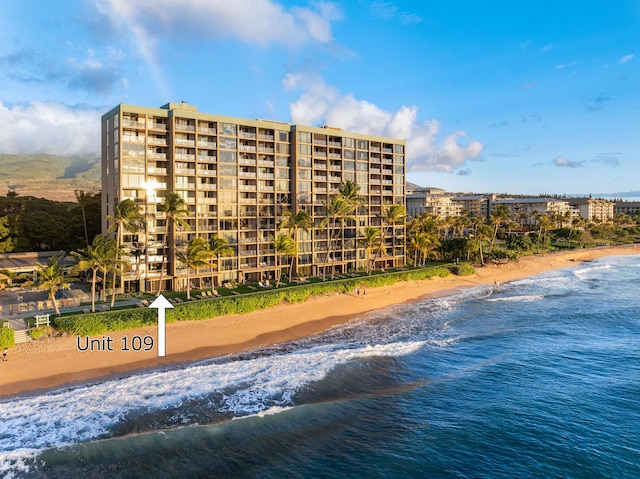 view of property with a water view and a beach view