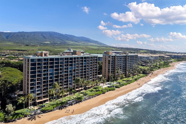 drone / aerial view featuring a water and mountain view and a beach view