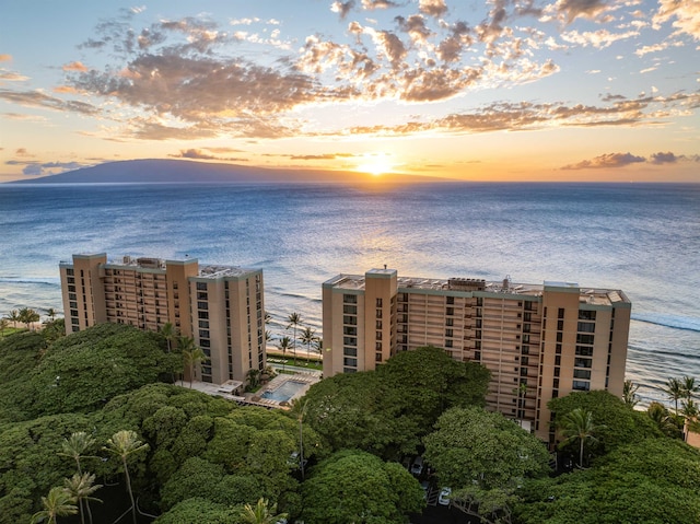 aerial view at dusk featuring a water view