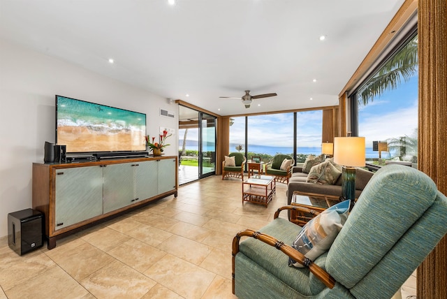 tiled living room featuring a wall of windows, ceiling fan, and plenty of natural light