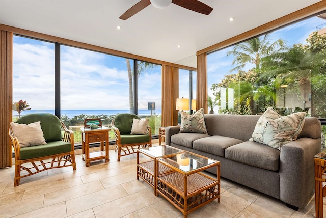 sunroom with ceiling fan, a water view, and a wealth of natural light