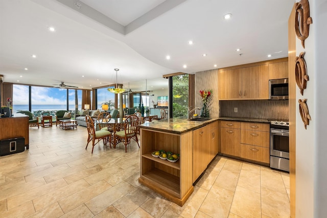 110 Kaanapali Shores Pl Unit 109, Lahaina, HI 96761 - kitchen with stainless steel appliances, expansive windows, decorative backsplash, a peninsula, and open floor plan