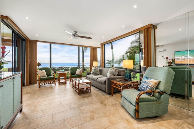 tiled living room with a wall of windows and ceiling fan