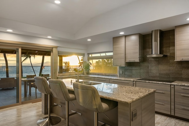 2274 S Kihei Rd, Kihei, HI 96753 - kitchen featuring wall chimney exhaust hood, light wood-type flooring, a breakfast bar area, backsplash, and vaulted ceiling