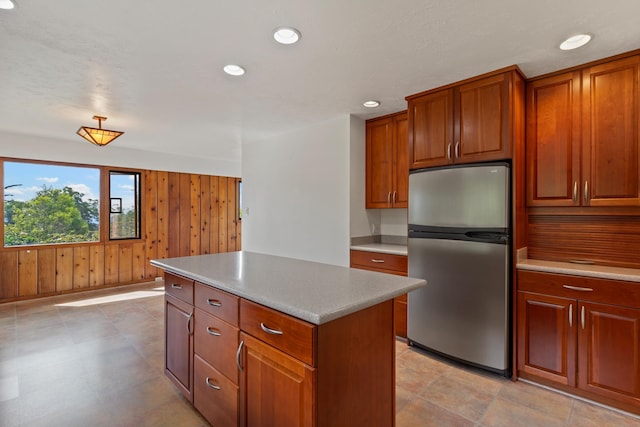 kitchen featuring light tile patterned floors, a center island, and stainless steel fridge