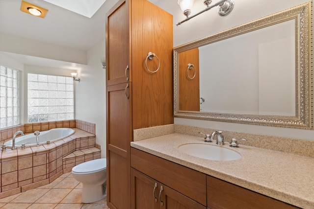 bathroom with tile patterned floors, tiled tub, vanity, and toilet