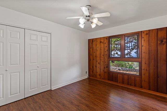 unfurnished bedroom featuring a closet, dark wood-type flooring, and ceiling fan