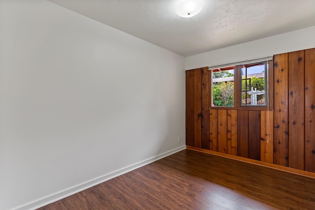 unfurnished room with dark hardwood / wood-style flooring