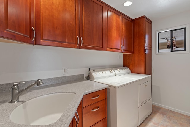 clothes washing area with cabinets, light tile patterned floors, sink, and independent washer and dryer