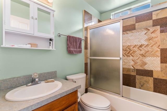 full bathroom featuring vanity, toilet, and shower / bath combination with glass door