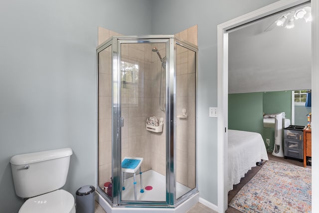 bathroom featuring toilet, tile patterned floors, and an enclosed shower