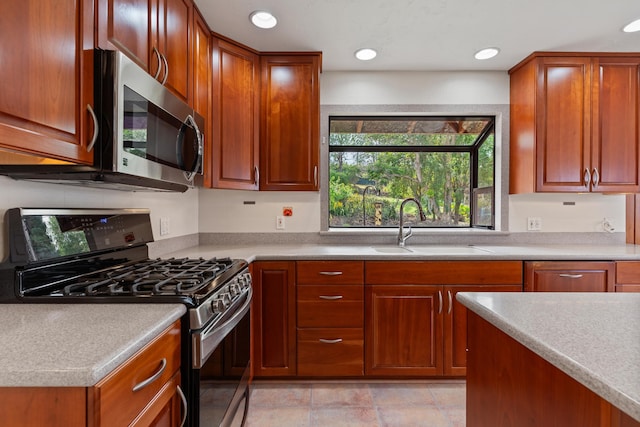 kitchen with sink, stainless steel appliances, and light tile patterned floors