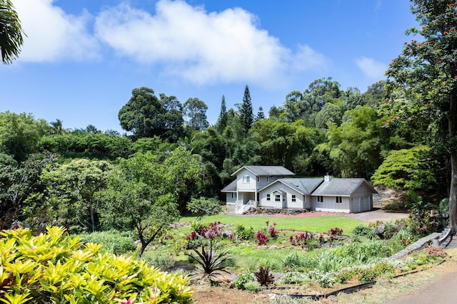 view of front of house with an attached garage, concrete driveway, and a front yard