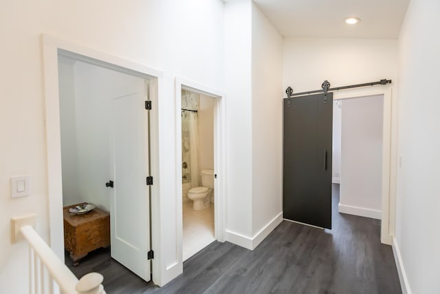 hall featuring recessed lighting, dark wood finished floors, baseboards, and a barn door