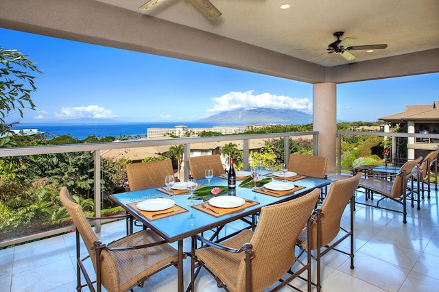 view of patio / terrace with a water and mountain view, a balcony, and ceiling fan