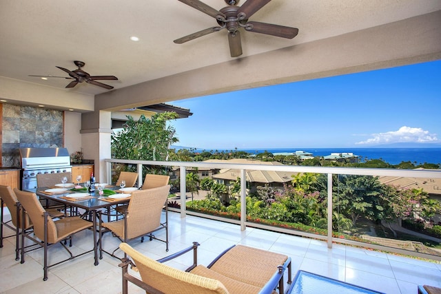 view of patio / terrace featuring an outdoor kitchen, grilling area, ceiling fan, and a water view