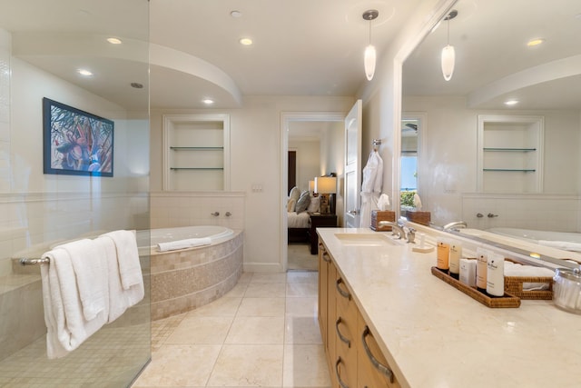 bathroom featuring vanity, tiled bath, tile patterned floors, and built in shelves