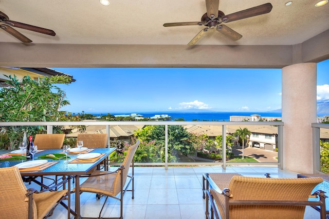 balcony featuring ceiling fan and a water view