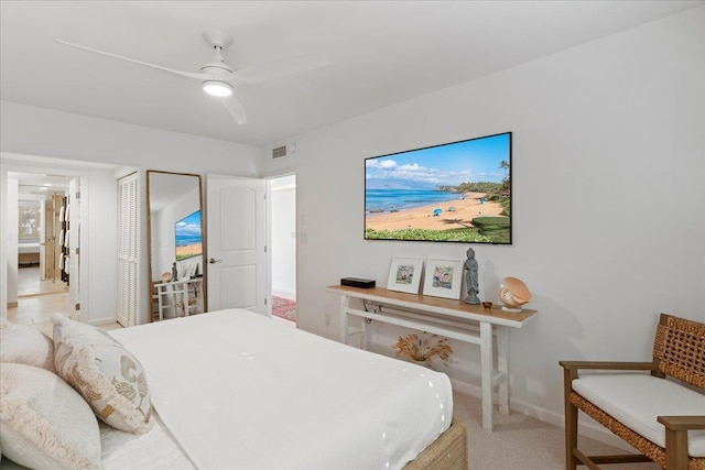 bedroom with a closet, ceiling fan, and light carpet