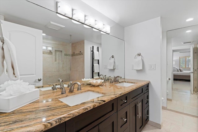 bathroom featuring a tile shower, tile patterned flooring, toilet, and vanity