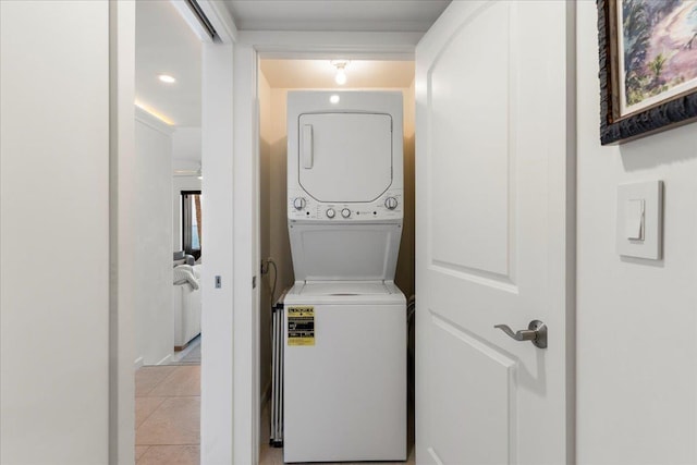 clothes washing area with light tile patterned floors and stacked washer / drying machine