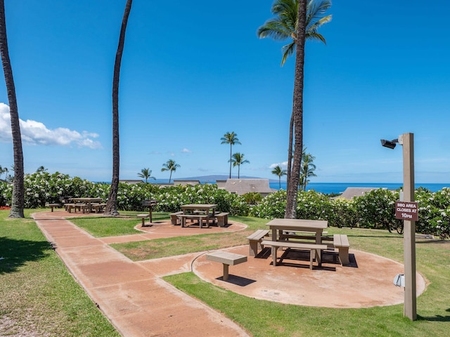 surrounding community featuring a water view and a lawn