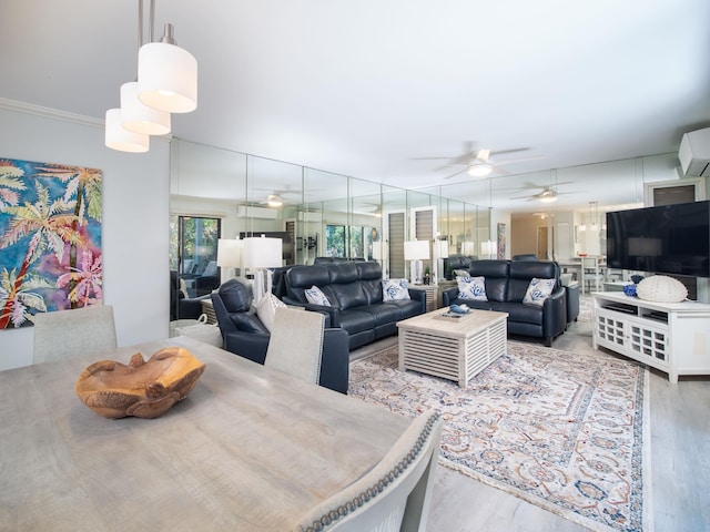 living room with an AC wall unit, ceiling fan, ornamental molding, and light wood-type flooring