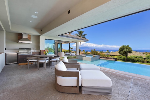 view of pool featuring exterior kitchen, a patio area, a mountain view, an in ground hot tub, and a grill