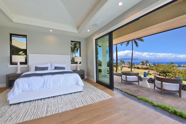 bedroom featuring lofted ceiling, light hardwood / wood-style flooring, and access to outside