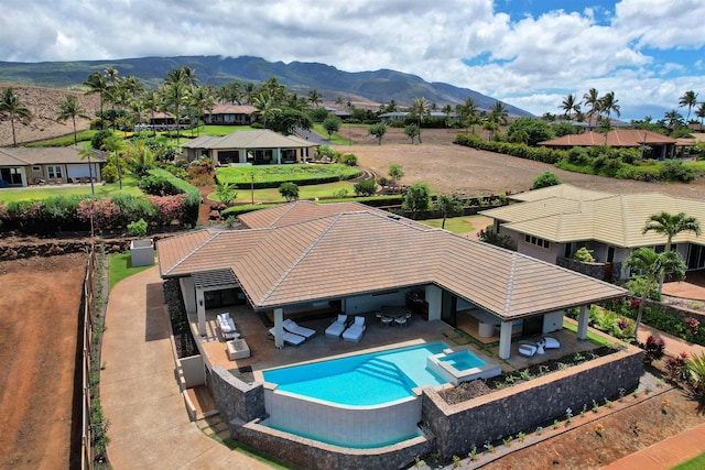 view of swimming pool featuring an in ground hot tub, a mountain view, and a patio area