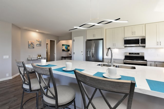 kitchen featuring white cabinets, dark hardwood / wood-style floors, backsplash, appliances with stainless steel finishes, and sink