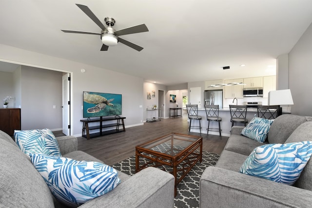 living room featuring ceiling fan and dark hardwood / wood-style flooring