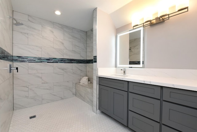 bathroom with tiled shower, oversized vanity, and tile flooring