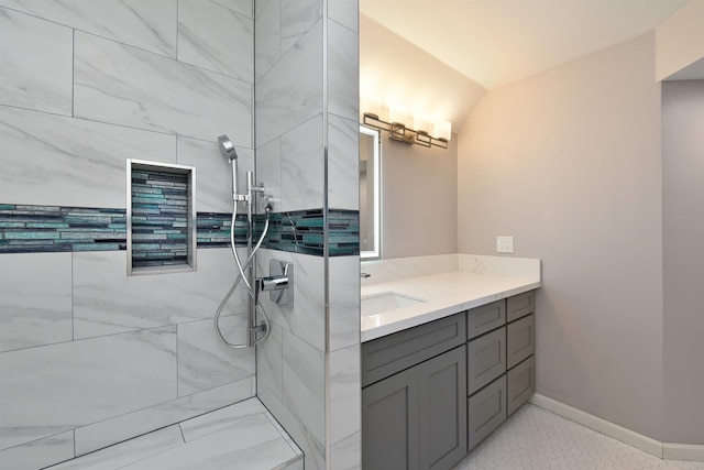 bathroom featuring vanity, a tile shower, and tile floors