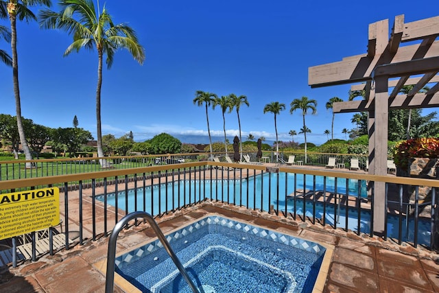 view of swimming pool with a hot tub and a pergola