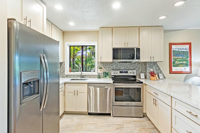 3788 Lower Honoapiilani Rd Unit D101, Lahaina, HI 96761 - kitchen featuring appliances with stainless steel finishes, decorative backsplash, recessed lighting, light stone counters, and a peninsula