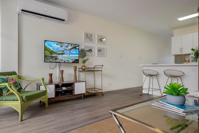 living room with light hardwood / wood-style floors and a wall unit AC