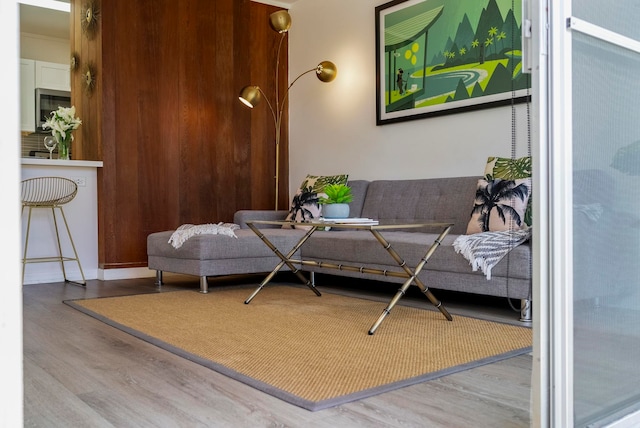 living area featuring hardwood / wood-style floors and wooden walls