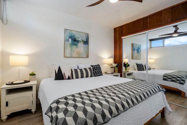 bedroom with ceiling fan, dark wood-type flooring, and a closet