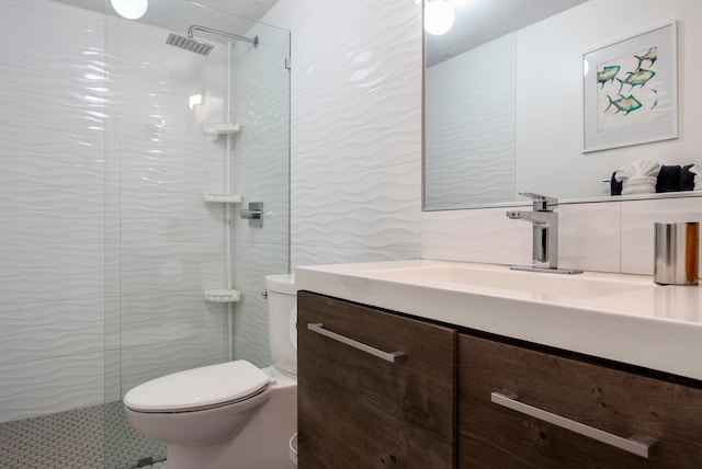 bathroom featuring a tile shower, vanity, and toilet