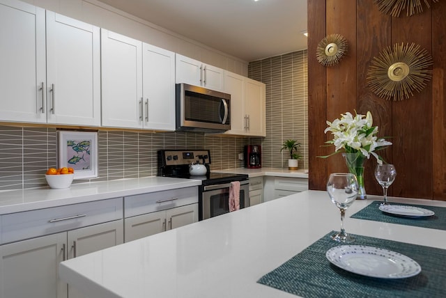 kitchen with decorative backsplash, white cabinetry, and stainless steel appliances