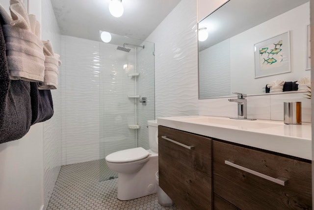 bathroom featuring tiled shower, tile patterned floors, vanity, and toilet